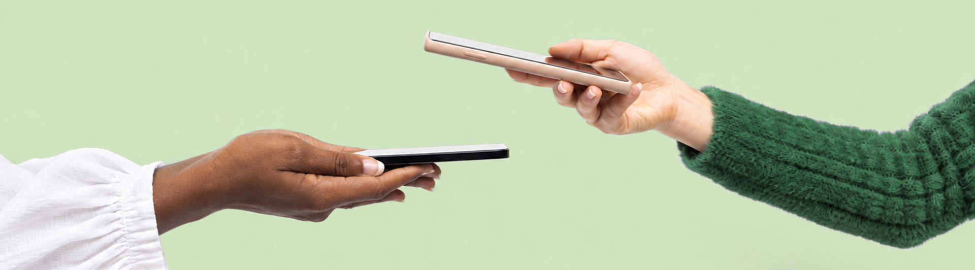 two hands holding phone against a green background